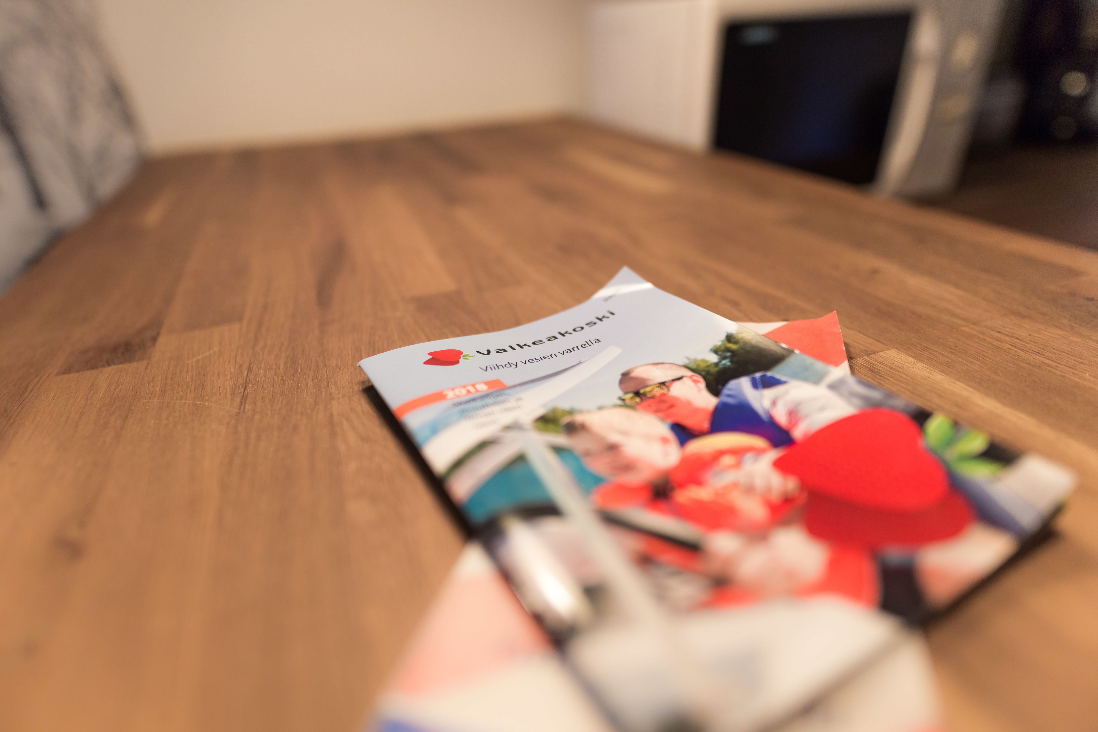 A brochure on a wooden table.