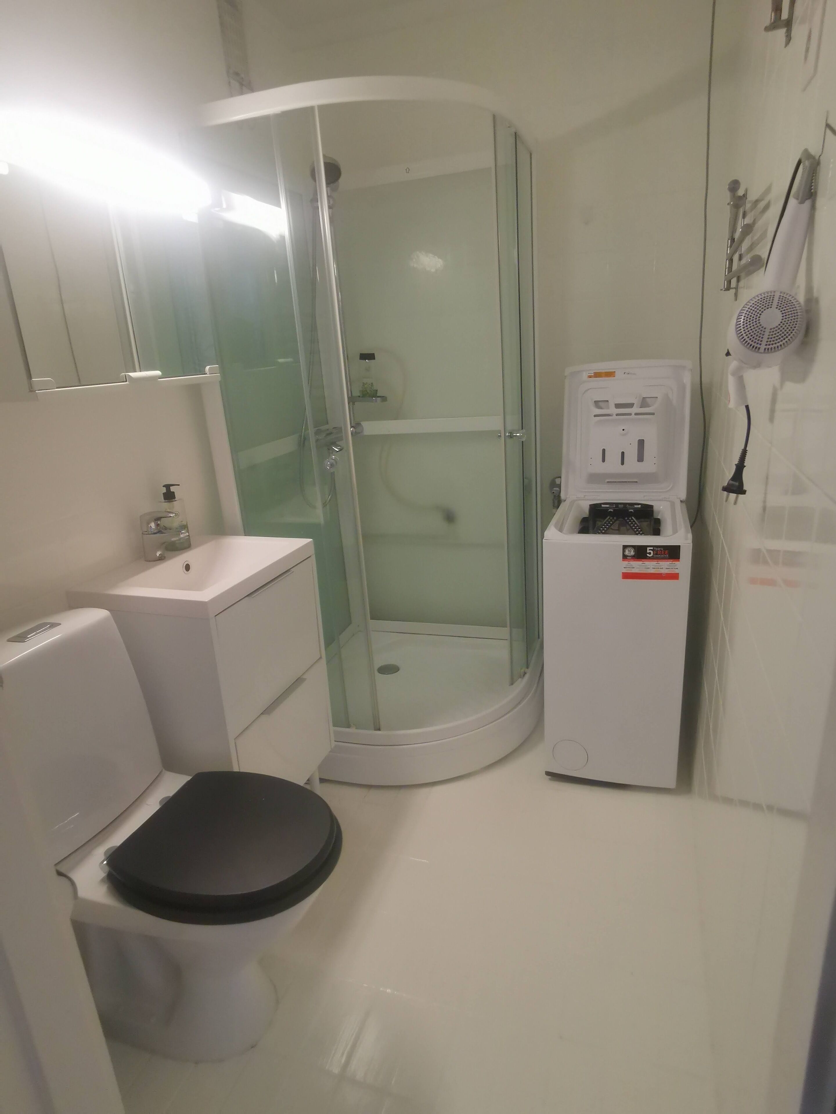 A bathroom with a toilet, sink, and glass-enclosed shower.