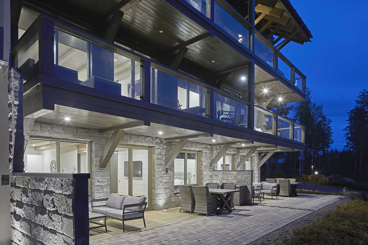 A multi-level outdoor living area with stone walls, a covered patio, and outdoor furniture.
