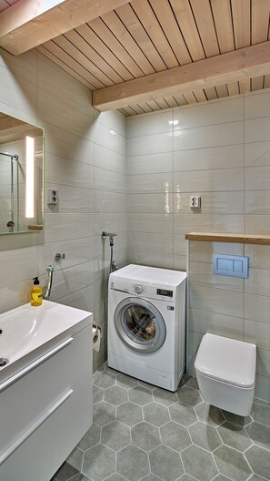 Un baño moderno con lavadora, inodoro y lavamanos.