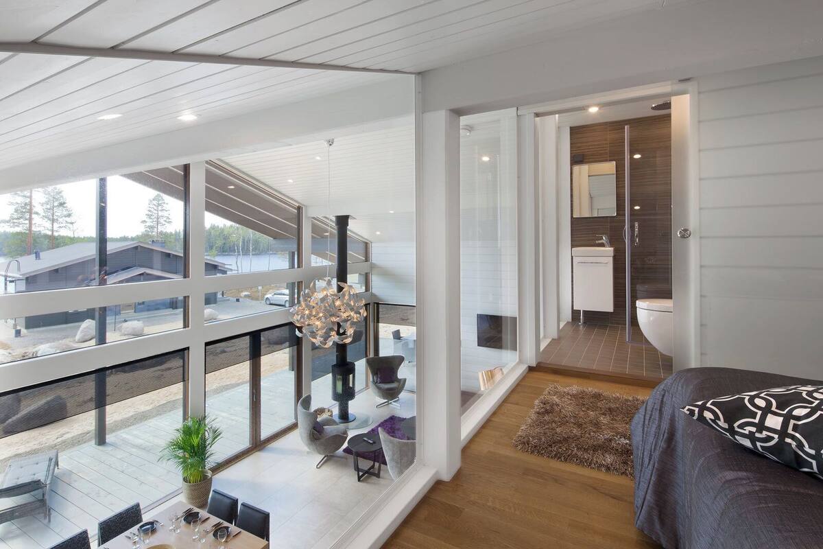 A modern interior with a dining area, a large window, and a view of the outside.