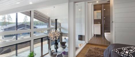 A modern interior with a dining area, a large window, and a view of the outside.