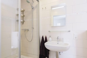 Habitación individual | Baño | Regadera y toallas 
