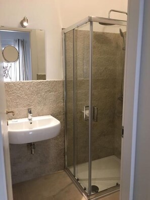 Habitación doble, 1 cama Queen size | Baño | Regadera, regadera tipo lluvia, amenidades de baño gratuitas, batas 