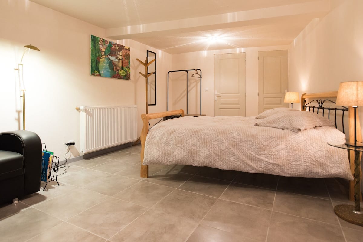 Ein Schlafzimmer mit Bett, Heizkörper, Schreibtisch und Stuhl.