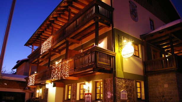 A building with a wooden balcony, stone walls, and a sign indicating a restaurant. - Pension Zur Alten Schmiede (Zwiesel)