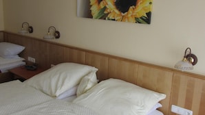 A hotel room with a bed, two bedside tables, a nightstand, and a wall-mounted lamp. - Pension Zur Alten Schmiede (Zwiesel)