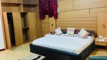 A bedroom with a bed, bedside tables, a wardrobe, and a red curtain.
