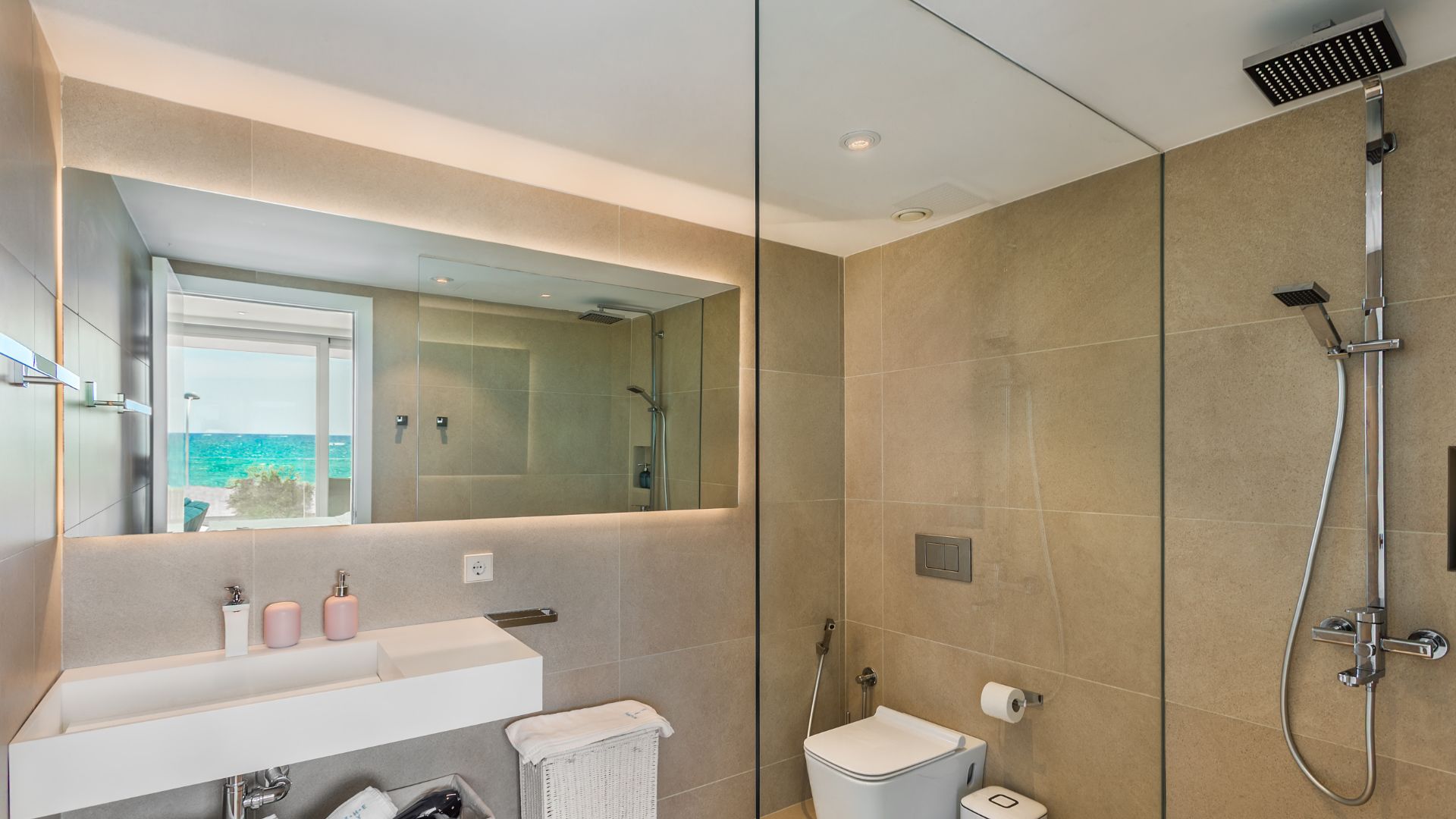 Een moderne badkamer met een grote spiegel, een douche en een toilet.