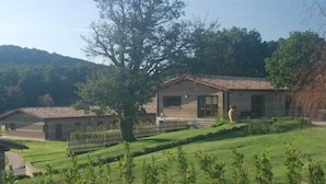 A rustic building with a tiled roof, a wooden fence, and a well-maintained lawn. - Agriturismo Monte dell'Olmo (Trevignano Romano)