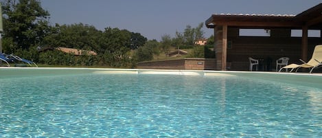 Una piscina al aire libre de temporada, sombrillas