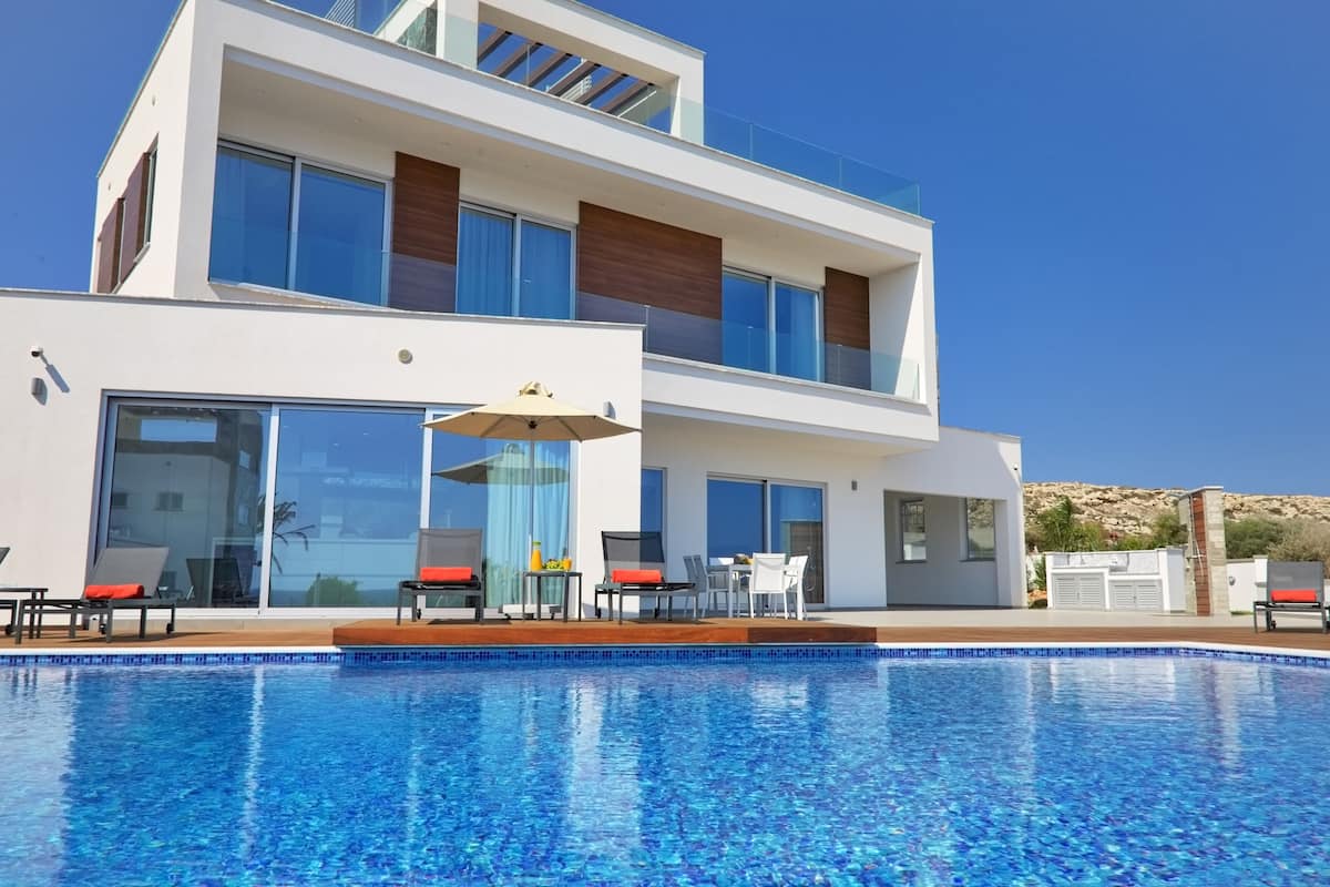 Un bâtiment moderne à deux étages avec une piscine devant.