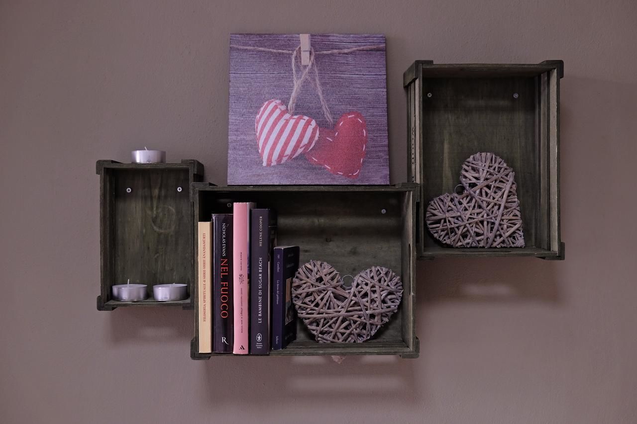 Three wooden boxes with heart-shaped decorations and books.