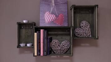 Three wooden boxes with heart-shaped decorations and books.