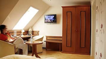 A room with a bed, a desk, a TV, and a wardrobe.