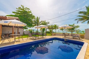 Una piscina al aire libre, tumbonas