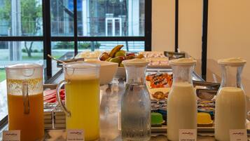 Un bufé de desayuno con diversas bebidas y alimentos.