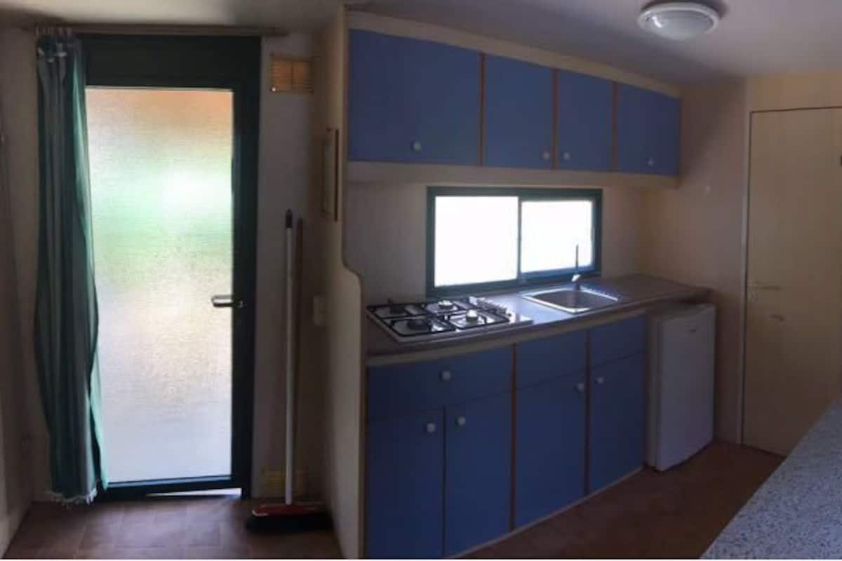 A compact kitchen with a window, a small sink, and a stove.