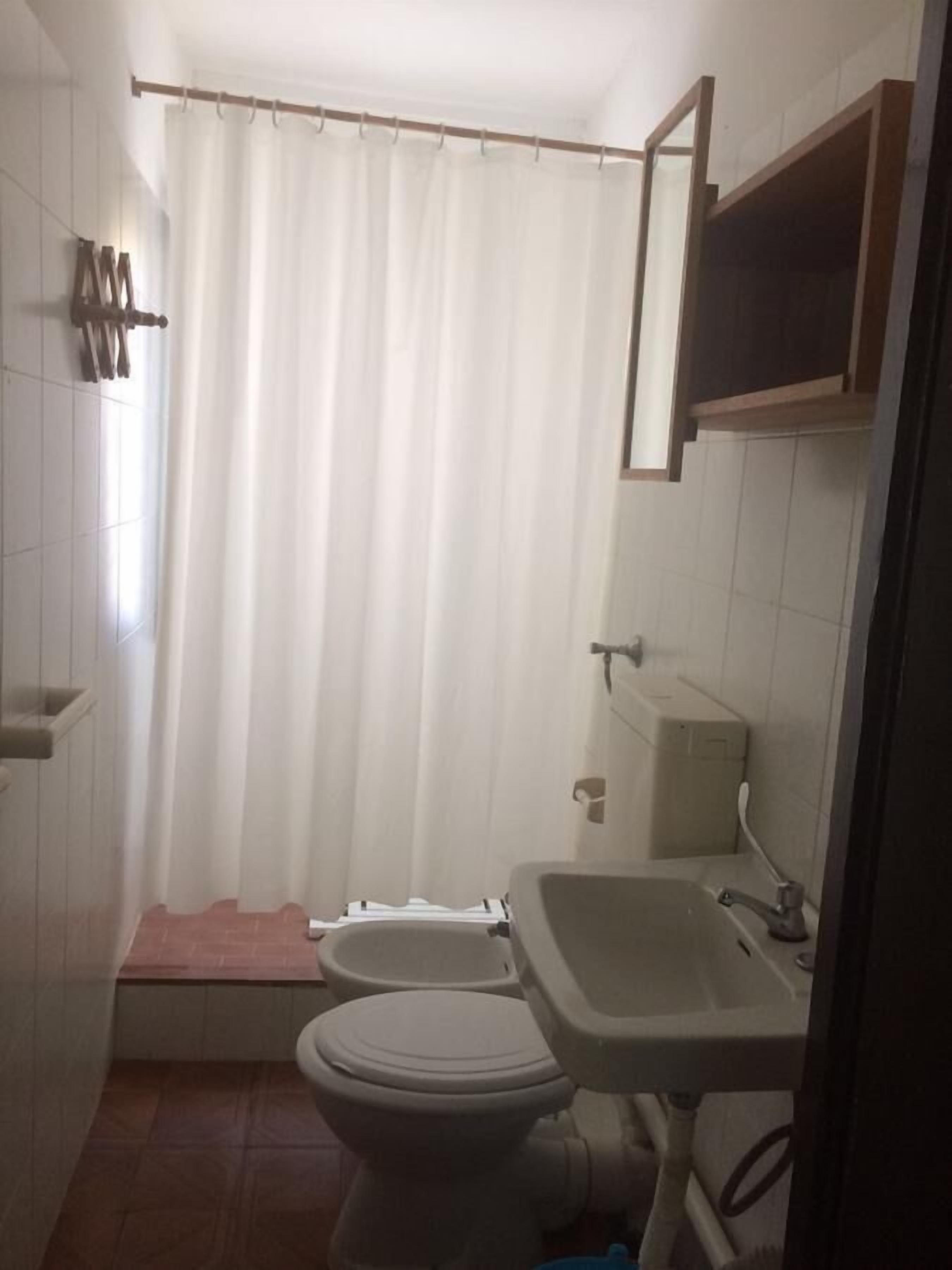 Un baño pequeño con inodoro, bidé y lavamanos.