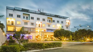 A multi-story hotel with a flat roof and a sign for R.G. Hotels & Resort. - R G Hotels and Resort (Malur)