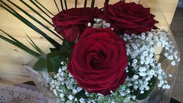 A bouquet of red roses and white flowers in a clear vase.