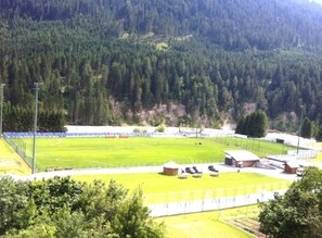 A sports field with seating and buildings, surrounded by forested hills. - Hotel Diana (Auronzo di Cadore)