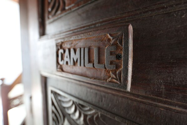 A wooden door with a nameplate that reads "CAMILLE".