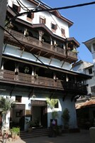 Un edificio de varios pisos con balcones ornamentados y una entrada central.