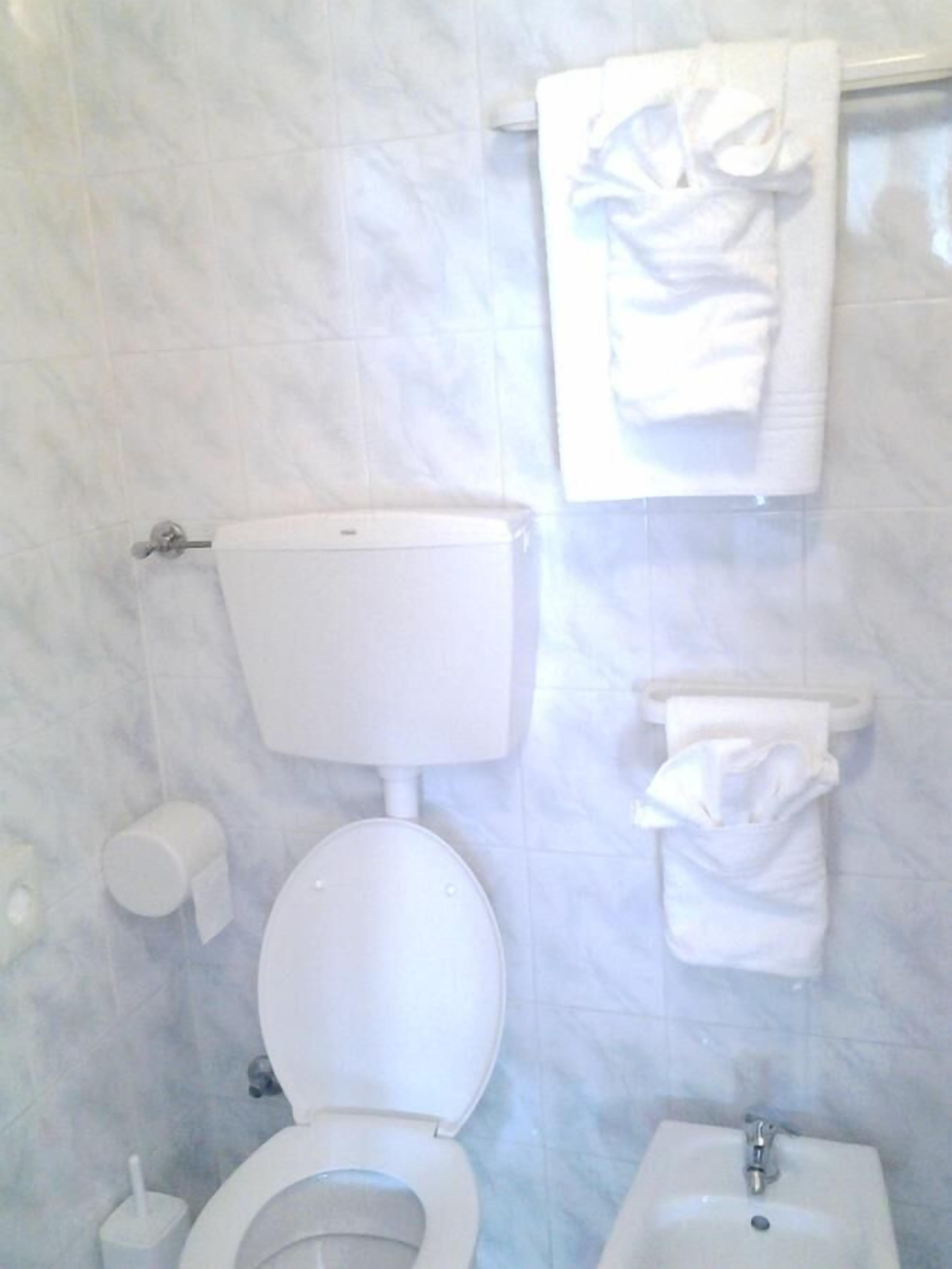 Ein Badezimmer mit Toilette, Bidet und Waschbecken.