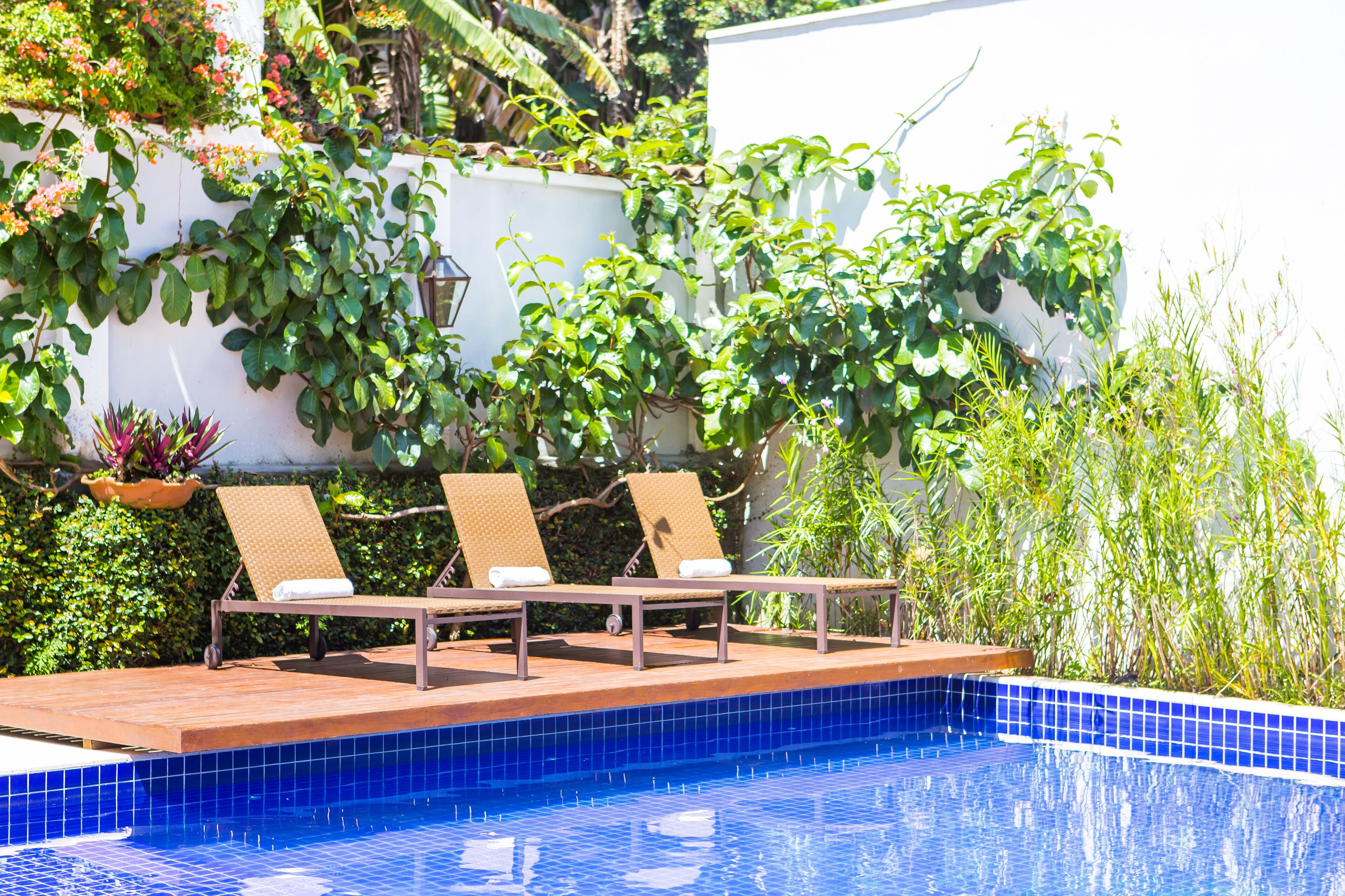 A poolside area with lounge chairs and a tiled pool.