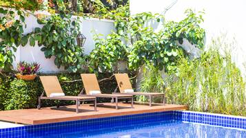 A poolside area with lounge chairs and a tiled pool.