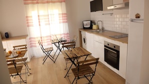 A compact kitchen with a dining area, a washing machine, and a microwave. - Maribà (Agrigento)