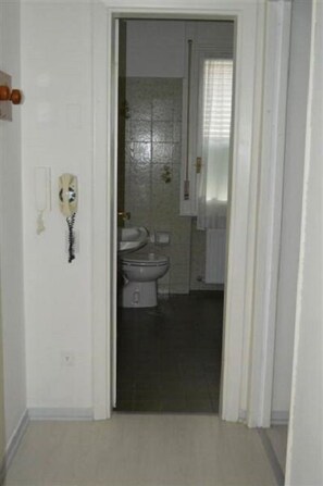 Un baño con inodoro, lavamanos y espejo.