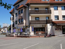 A hotel with a sign reading "CITY HOTEL" and "Mark Michelstadt" on the facade.