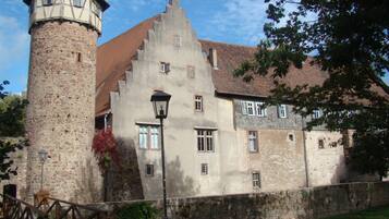A historic building with a stone tower and a large, multi-story structure with several windows.