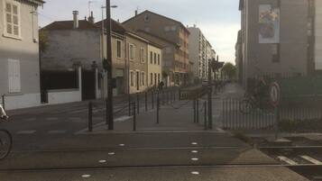 Une vue de rue avec des bâtiments, un passage piéton et un vélo.