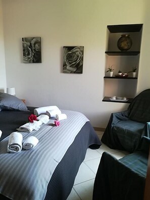 A hotel room with a bed, a chair, and artwork on the wall. - Bed & Breakfast da Luca (Bonassola)