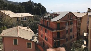 A multi-story residential building with balconies and a hilly background. - Bed & Breakfast da Luca (Bonassola)