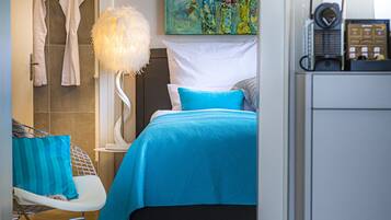 Une chambre à coucher moderne avec un lit, une chaise, une lampe et un tableau au mur.