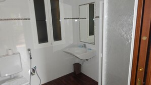 Une salle de bain avec des toilettes, un lavabo et une douche.