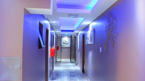 A modern hallway with a polished tile floor, recessed lighting, and a fire extinguisher mounted on the wall. - Angel Guest House (Johannesburg)