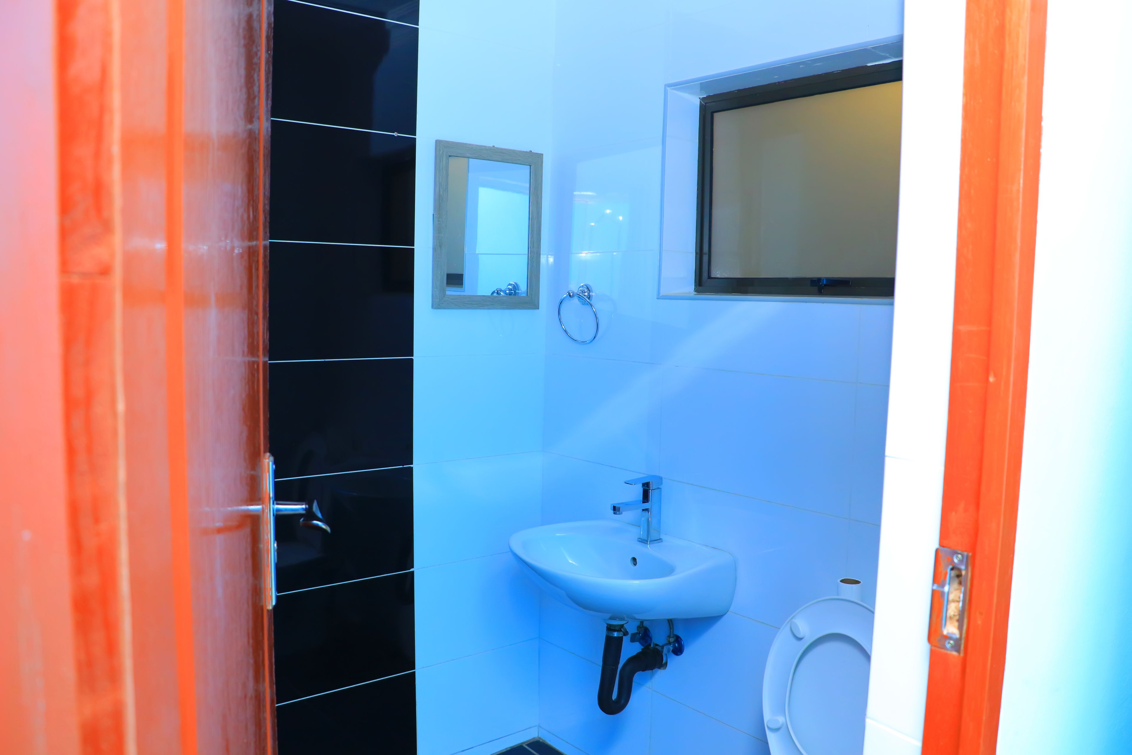 A bathroom with a sink, toilet, and mirror.