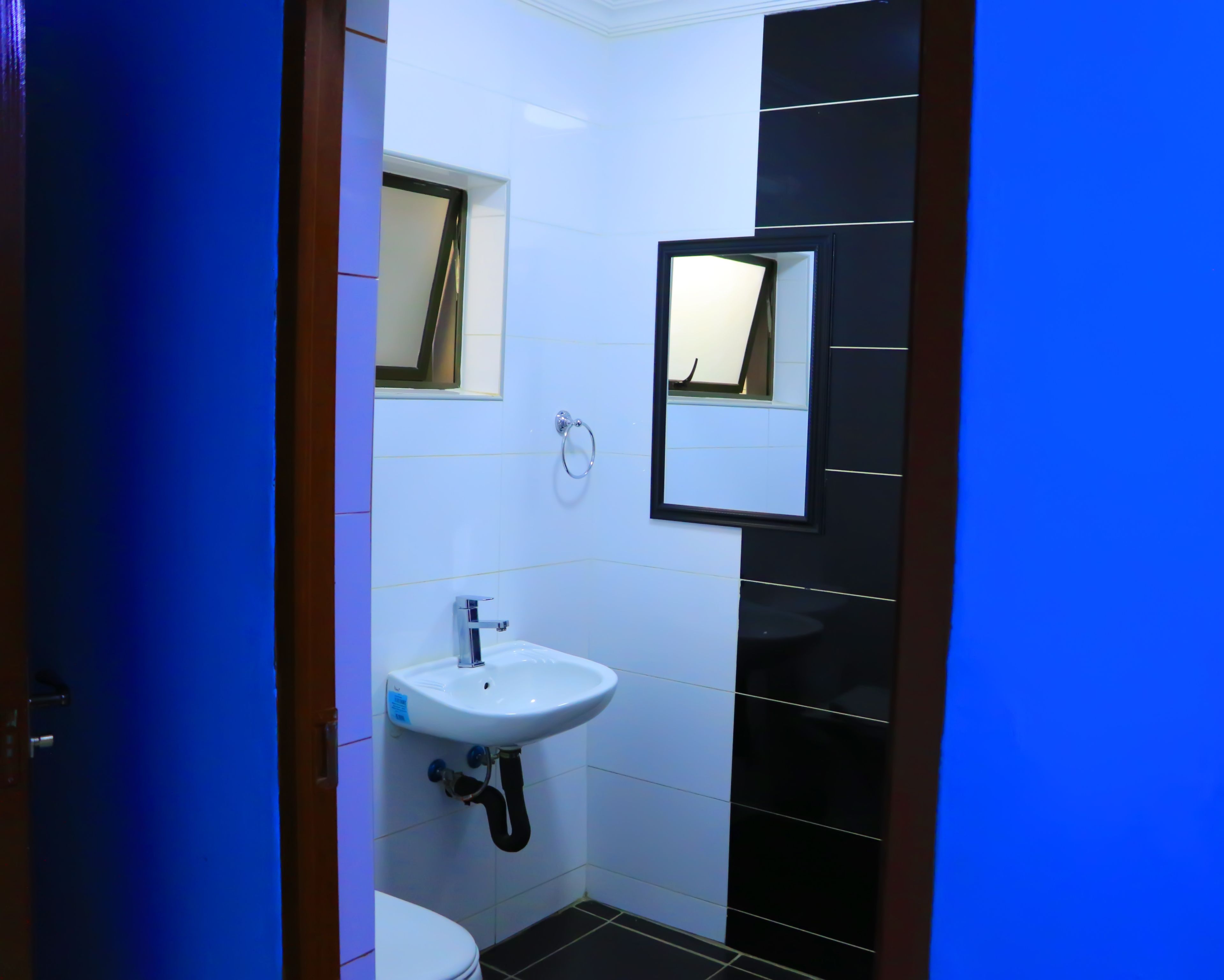 A bathroom with a white sink, a mirror, and a toilet.
