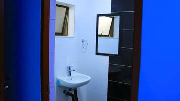 A bathroom with a white sink, a mirror, and a toilet.