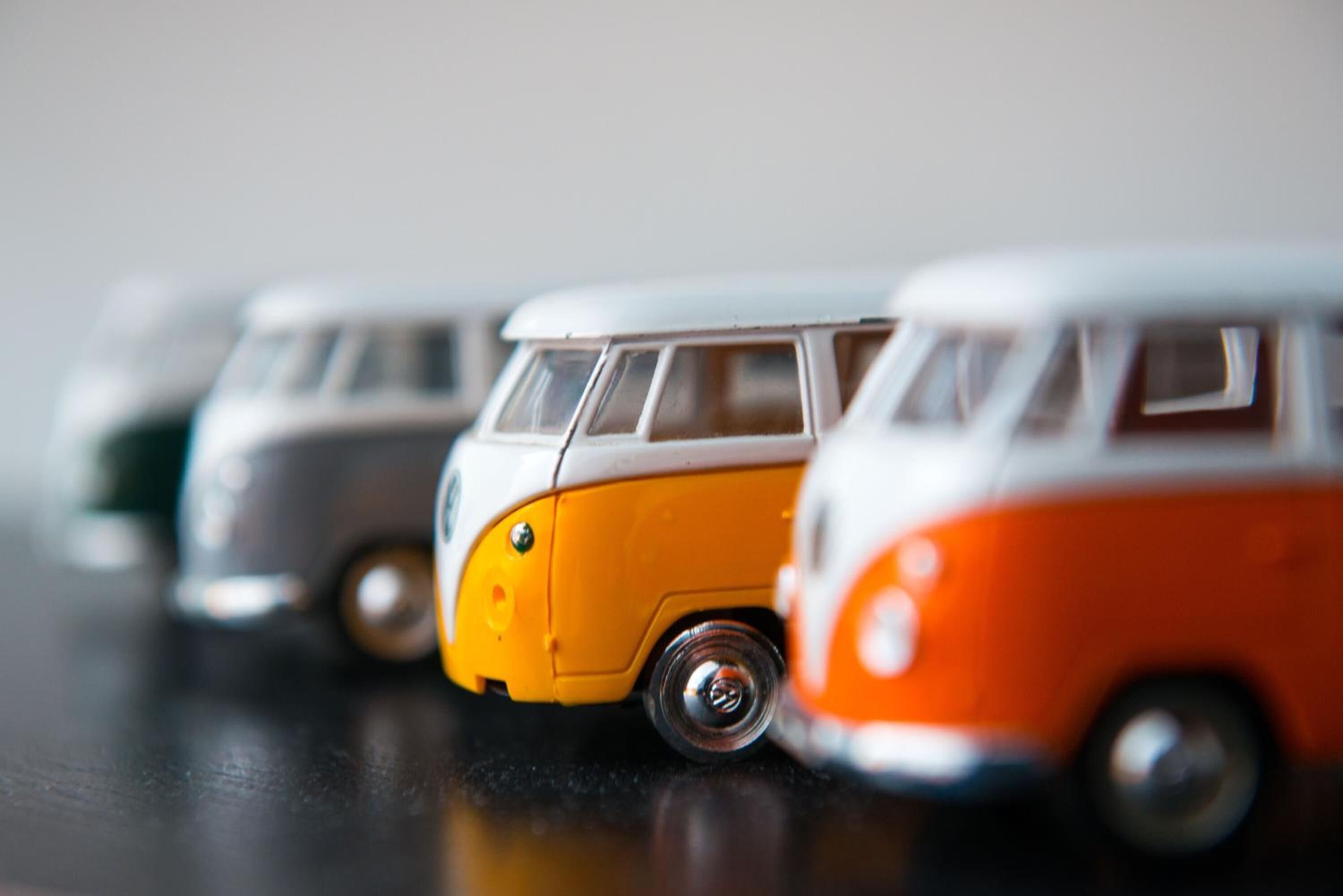 Eine Reihe von Spielzeug-Transportern in Weiß, Orange und Grau.