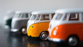 Eine Reihe von Spielzeug-Transportern in Weiß, Orange und Grau.
