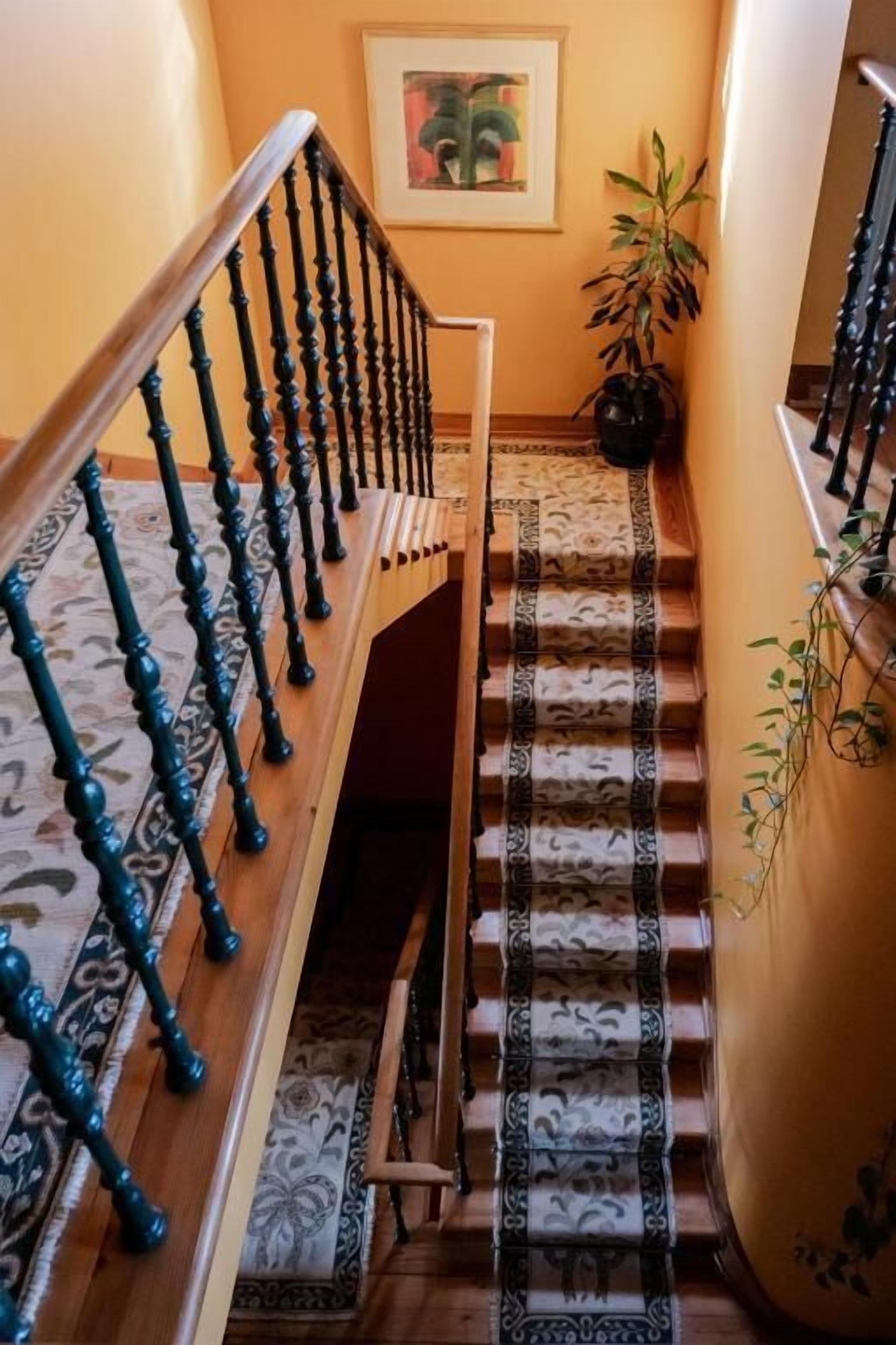 A staircase with patterned carpet and a railing.