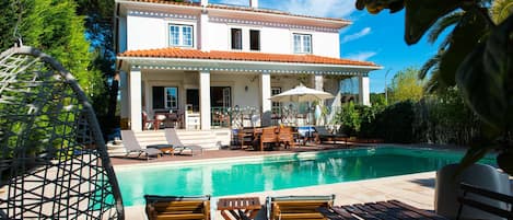 Una piscina al aire libre, tumbonas