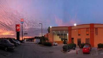 A Red Carpet Inn with a parking lot and a sunset sky.