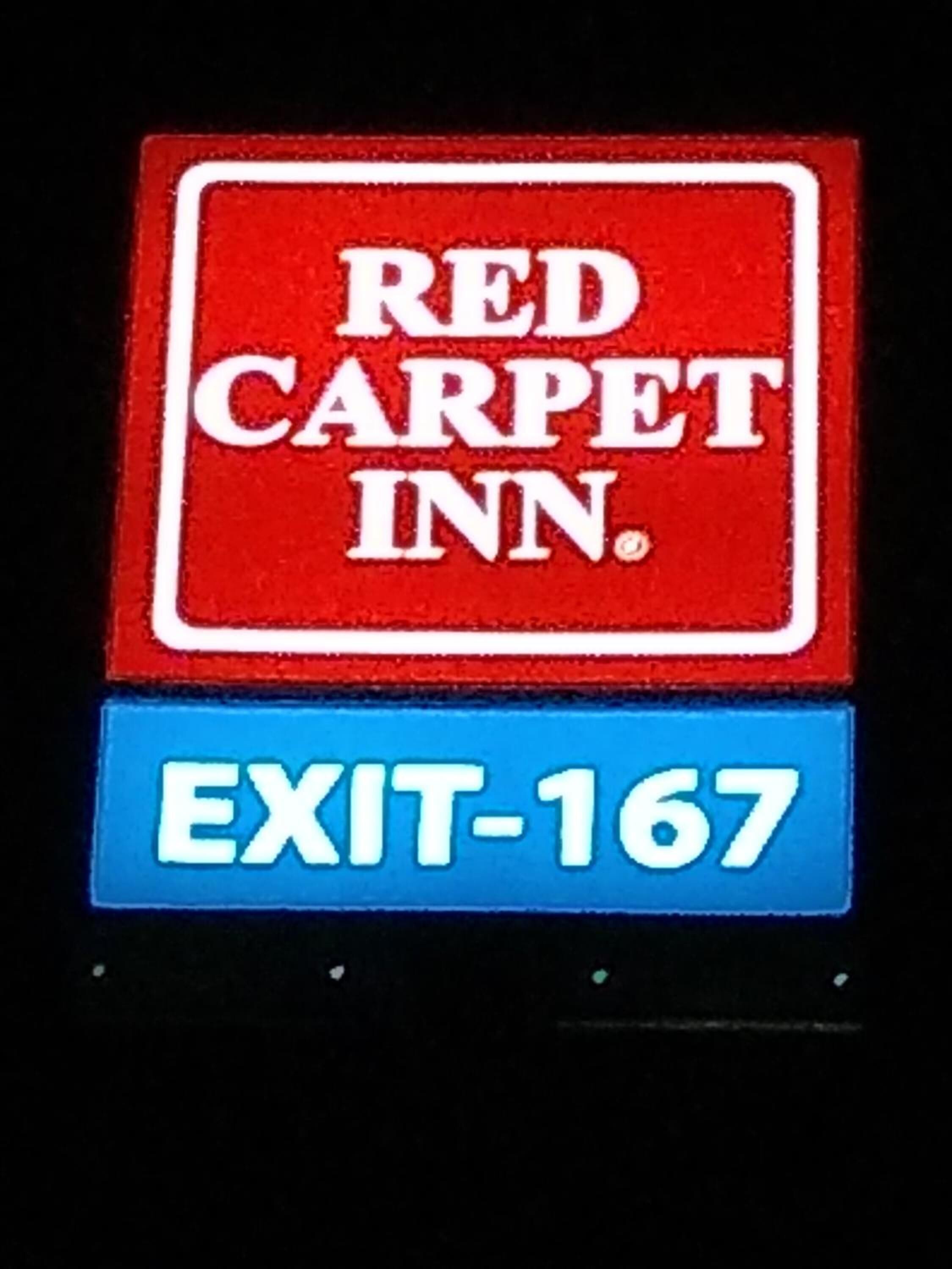 A sign with "RED CARPET INN" and "EXIT-167".